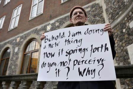 A man holds a placard during a vigil against Anglican Homophobia, outside the General Synod of the Church of England in London, Britain, February 15, 2017. REUTERS/Hannah McKay