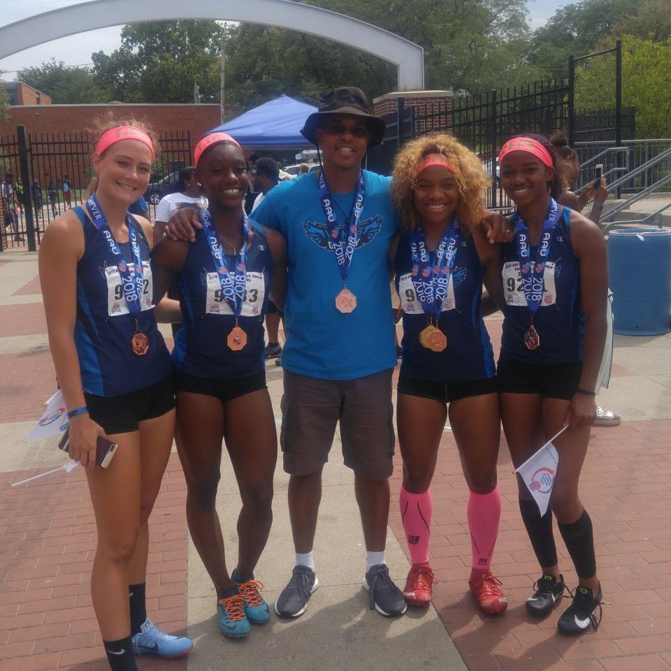 Wings of Glory head coach and co-founder James Malone, center,  poses with Wings of Glory's fourth-place 4x100 relay team of, from left, Tatum Straw, Makayla Jackson, Armoni Brown and Ja'Cey Simmons at the 2018 AAU Track and Field National Championships. Wings of Glory will bring 36 athletes to the 2022 AAU national meet next week.