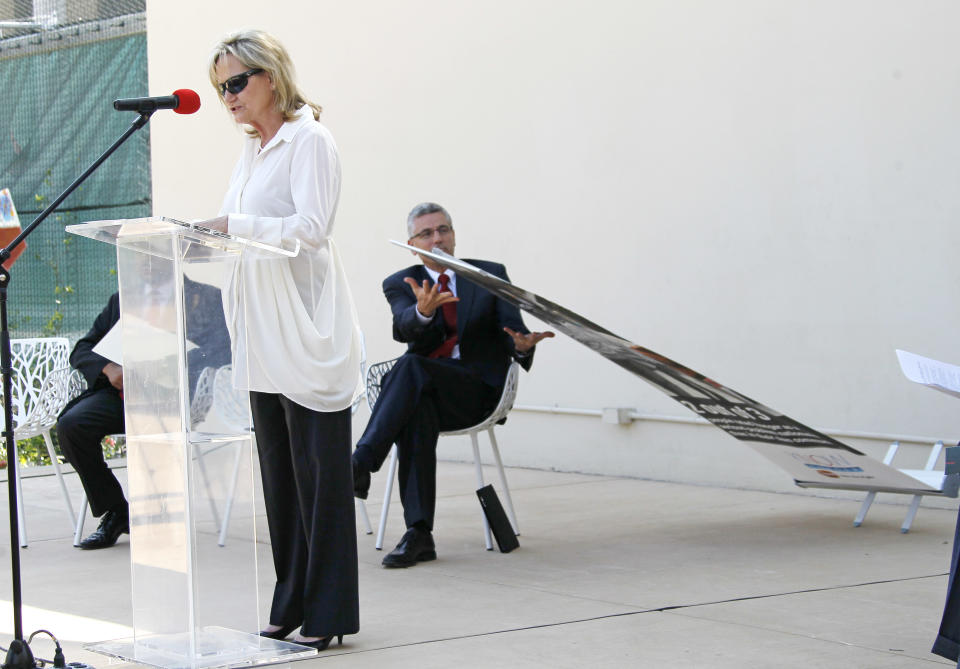 Donnie Smith, CEO and president of Tyson Foods Inc., catches a poster that falls while Mississippi Agriculture and Commerce Commissioner Cindy Hyde-Smith makes her comments at the announcement of Tyson's participation in a pilot program with the National Urban League targeting hunger in Mississippi, Thursday, June 21, 2012, in Jackson, Miss. The program is designed to reduce hunger in Mississippi, one of the poorest states in the nation. (AP Photo/Rogelio V. Solis)