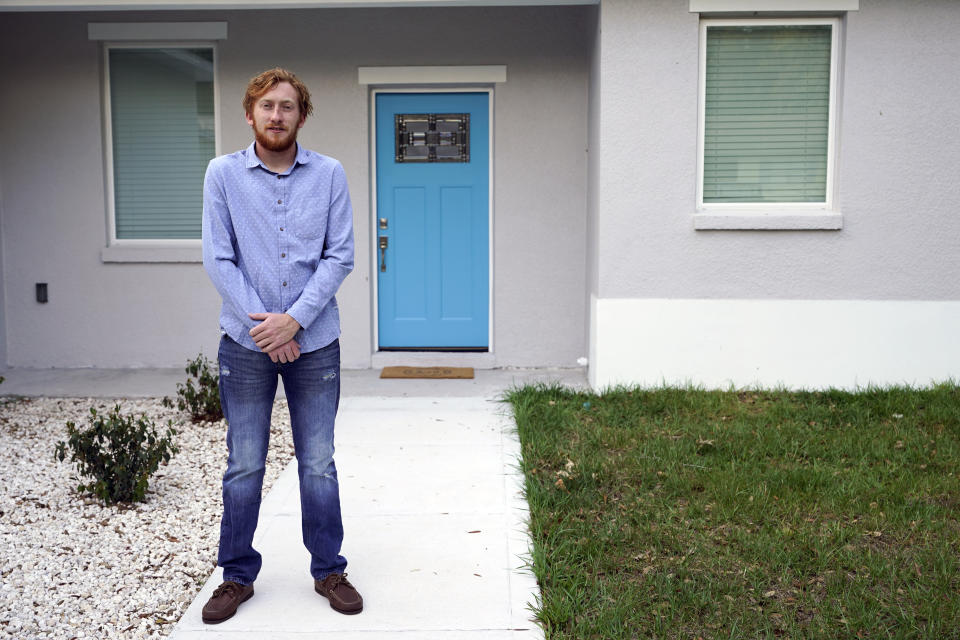 First-time buyer Kevin Muglach stands in front of his new home, Tuesday, April 6, 2021, in Orange City, Fla. Homebuyers are facing the most competitive U.S. housing market in decades this spring, as surging prices and a record-low number of homes for sale narrow the already difficult path to home ownership for many Americans. (AP Photo/John Raoux)