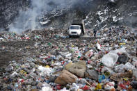 A trash truck unloads at the burning landfill near Priboj, in southwest Serbia, Friday, Jan. 22, 2021. Serbia and other Balkan nations are virtually drowning in communal waste after decades of neglect and lack of efficient waste-management policies in the countries aspiring to join the European Union. (AP Photo/Darko Vojinovic)