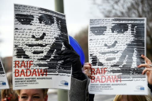 Amnesty International hold up portraits of jailed Saudi blogger Raif Badawi in front of the Saudi embassy Berlin in January 2016