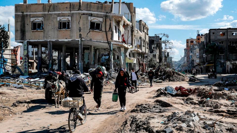 PHOTO: People walk past destroyed buildings in the Maghazi camp for Palestinian refugees, which was severely damaged by Israeli bombardment in the central Gaza Strip, Feb. 1, 2024.  (Anas Baba/AFP via Getty Images)