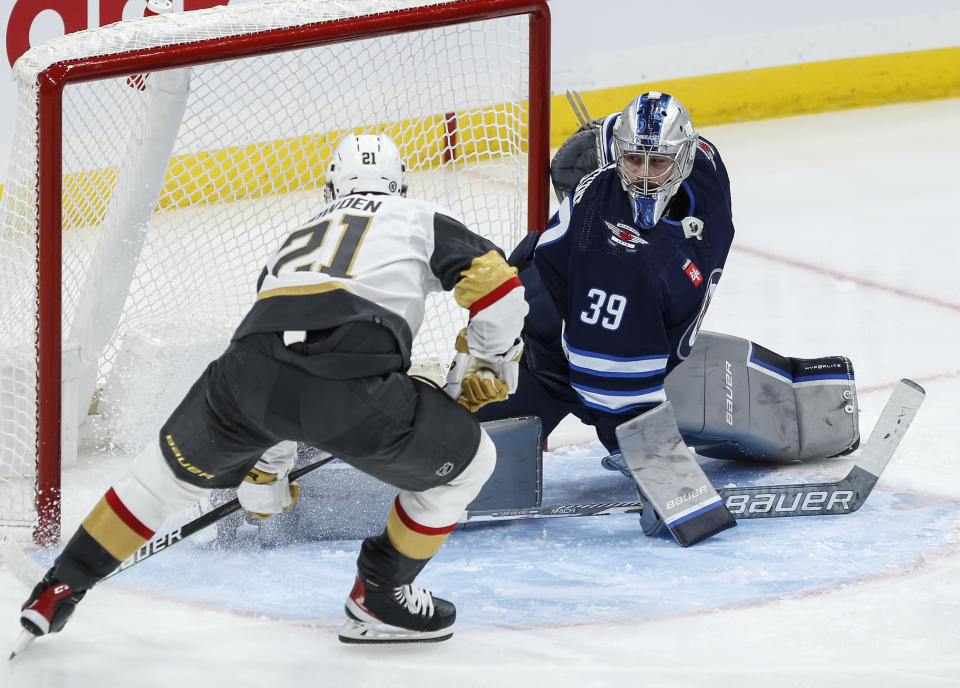 Vegas Golden Knights' Brett Howden (21) scores against Winnipeg Jets goaltender Laurent Brossoit (39) during second-period NHL hockey game action in Winnipeg, Manitoba, Thursday, Oct. 19, 2023. (John Woods/The Canadian Press via AP)