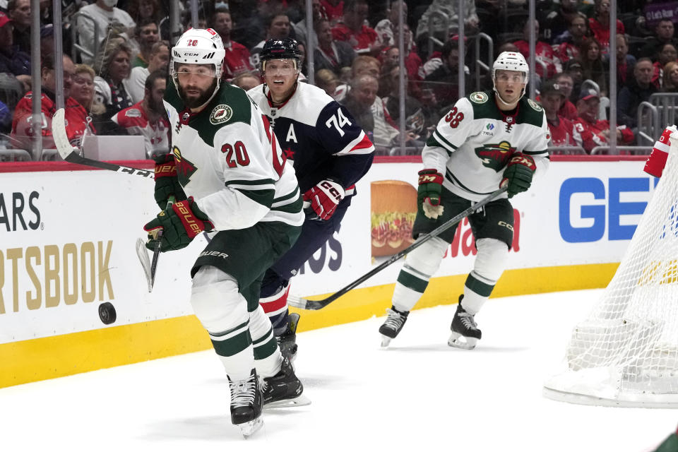 Minnesota Wild left wing Pat Maroon (20) knocks the puck away from Washington Capitals defenseman John Carlson (74) during the second period of an NHL hockey game Friday, Oct. 27, 2023, in Washington. (AP Photo/Mark Schiefelbein)