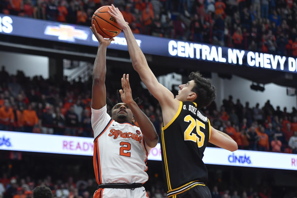 Pittsburgh forward Guillermo Diaz Graham, right, blocks a shot by Syracuse guard J.J. Starling during the second half of an NCAA college basketball game in Syracuse, N.Y., Saturday, Dec. 30, 2023. (AP Photo/Adrian Kraus)