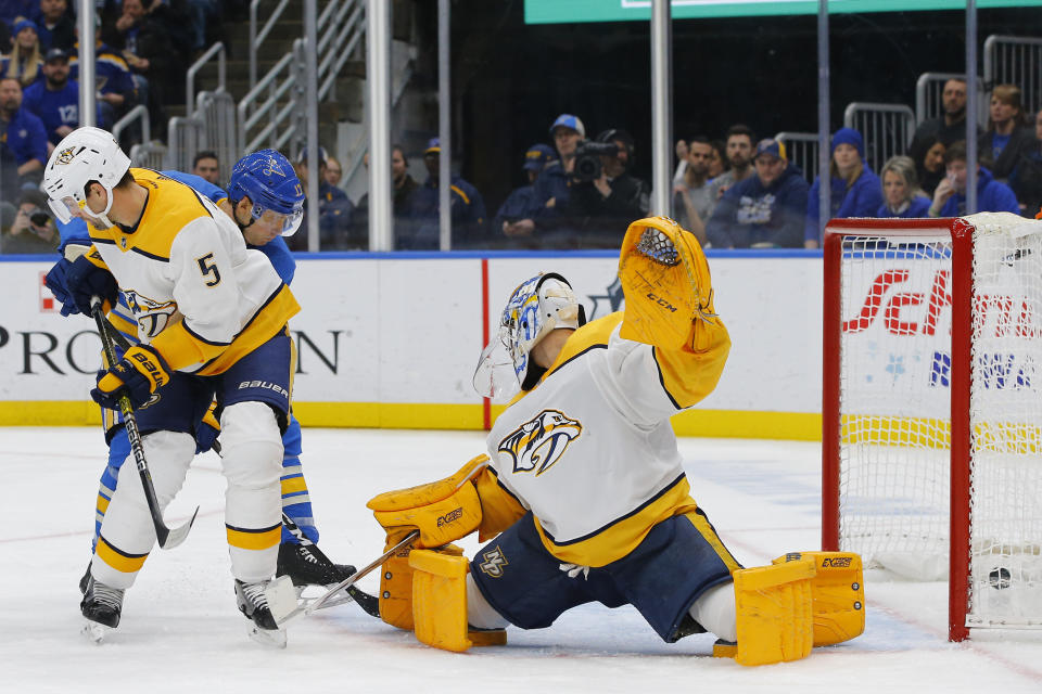 St. Louis Blues' Jaden Schwartz, back left, scores a goal against Nashville Predators goaltender Juuse Saros, of Finland, as Dan Hamhuis defends during the second period of an NHL hockey game Saturday, Feb. 15, 2020, in St. Louis. (AP Photo/Billy Hurst)