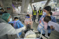 A public health worker gathers information from Chinese tourists from Shanghai, who arrived at Suvarnabhumi airport on special tourist visas, in Bangkok, Thailand, Tuesday, Oct. 20, 2020. Thailand on Tuesday took a modest step toward reviving its coronavirus-battered tourist industry by welcoming 39 visitors who flew in from Shanghai, the first such arrival since normal traveler arrivals were banned almost seven months ago. (AP Photo/Wason Wanichakorn)