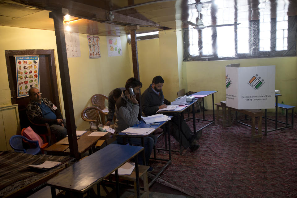 FILE - In this April 18, 2019, file photo, election officers sit inside an empty polling station during the second phase of India's general elections, in Srinagar, Indian controlled Kashmir, as Kashmiri separatist leaders have called for a boycott of the vote. In the world’s largest democracy, few issues reach as broad a consensus as Kashmir, that the Muslim-majority region must remain part of Hindu-majority India. Indian Prime Minister Narendra Modi is using this, and a February attack on Indian paramilitary forces in Kashmir, to consolidate the Hindu vote in India’s five-week elections that conclude May 21 to bolster his campaign-slogan claim to be India’s chowkidar, or watchman. (AP Photo/ Dar Yasin)