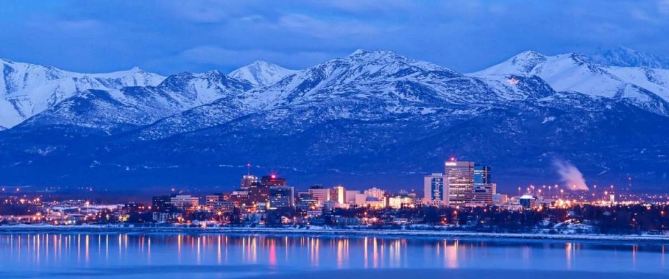 Anchorage Alaska skyline in winter at dusk with the Chugach mountains behind.