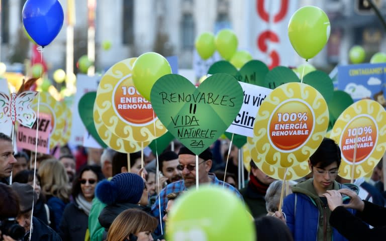 Participants hold placards against the climate change during the "Global Climate March" on November 29, 2015 in Madrid, called by environmental NGOs on the eve of the COP21