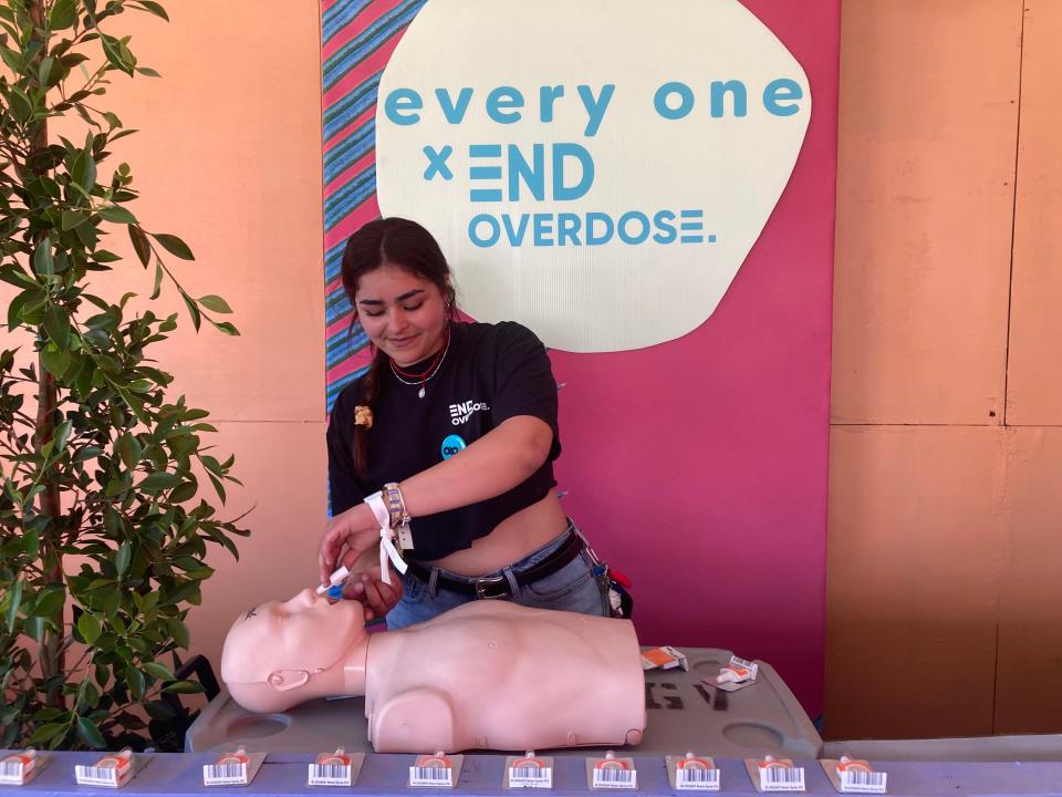 Natalie Loarca with End Overdose demonstrates how to administer Naloxone at the every one tent.