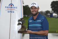 Marc Leishman of Australia holds up the winner's trophy after winning the Farmer's Insurance Open at the Torrey Pines Golf Course Sunday Jan. 26, 2020, in San Diego. (AP Photo/Denis Poroy)