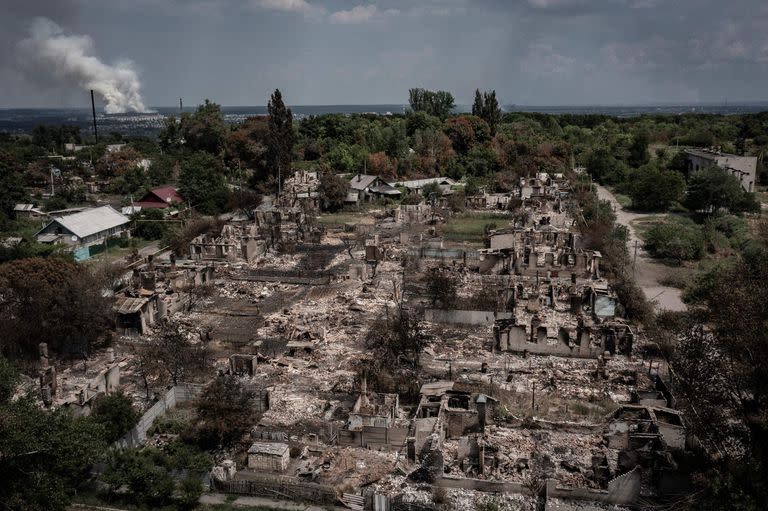 Una vista aérea muestra casas destruidas después de un ataque en la ciudad de Pryvillya en la región de Donbass, en el este de Ucrania, el 14 de junio de 2022, en medio de la invasión rusa de Ucrania. (Photo by ARIS MESSINIS / AFP)