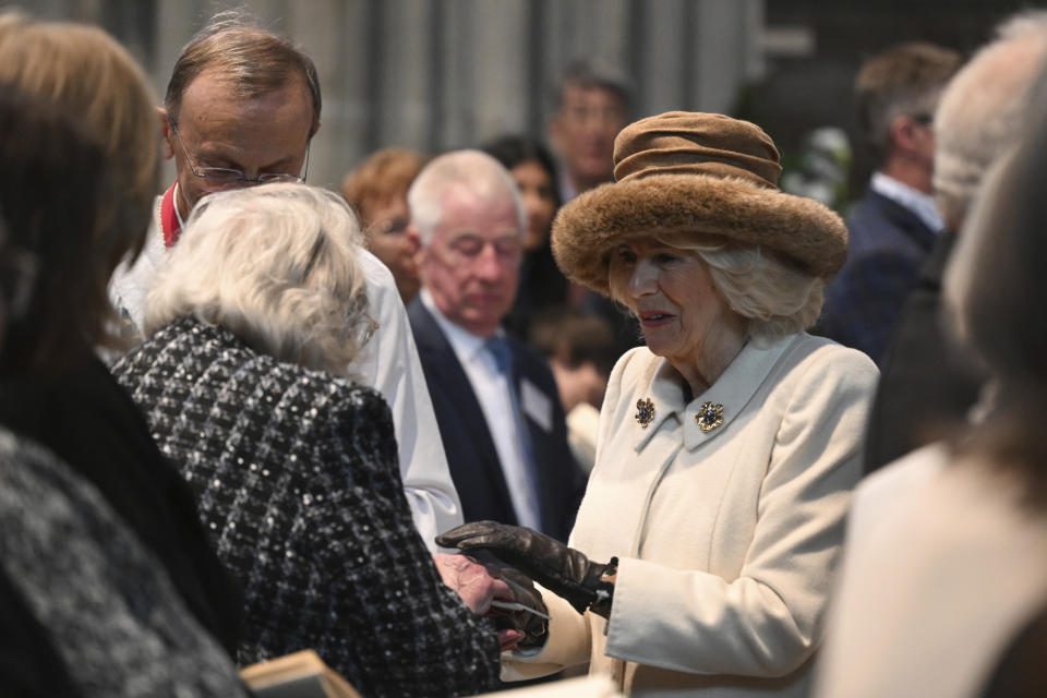 Britain's Queen Camilla hands out the Maundy Money during the Royal Maundy Service in Worcester, England, Thursday, March 28, 2024. Maundy Thursday is the Christian holy day falling on the Thursday before Easter. The monarch commemorates Maundy by offering 'alms' to senior citizens. Each recipient receives two purses, one red and one white. (Justin Tallis, Pool Photo via AP)