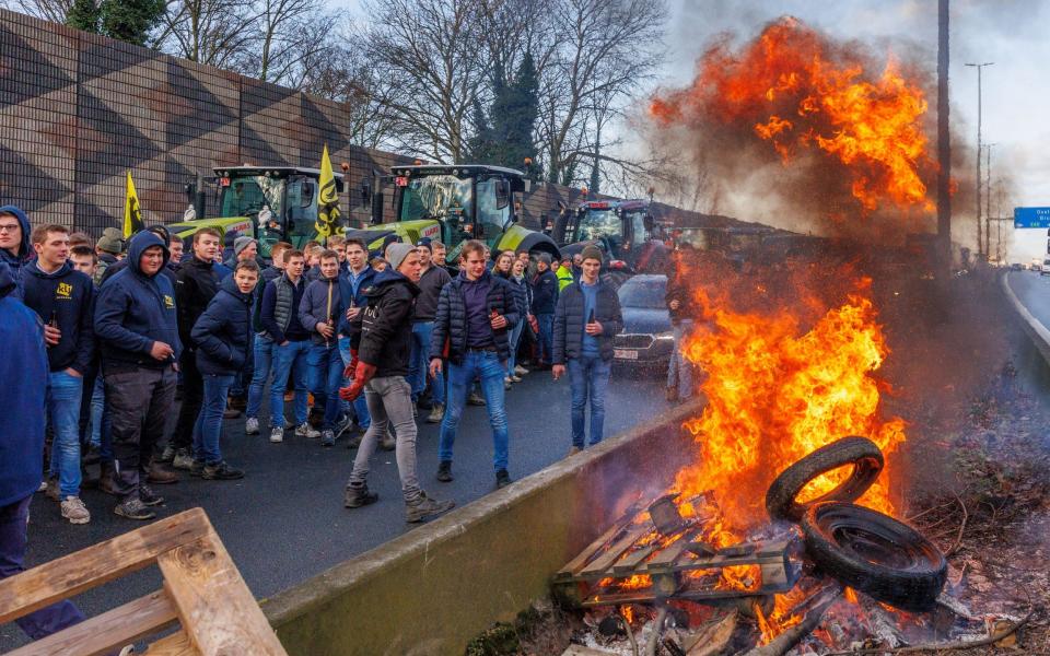 Belgian farmers burn wooden pallets and tyres as they block the highway in Aalter, Belgium,