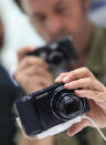 BERLIN, GERMANY - AUGUST 30: A visitor tries out the new Samsung Galaxy Camera, which combines a smartphone and a digital camera with a zoom lens, during a press day at the Samsung stand at the IFA 2012 consumer electronics trade fair on August 30, 2012 in Berlin, Germany. IFA 2012 will be open to the public from August 31 through September 5. (Photo by Sean Gallup/Getty Images)