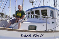 Salmon fisherman Mike Hudson sits on the bow of his boat at the Berkeley, Calif., Marina on Thursday, July 22, 2021. Baby salmon are dying by the thousands in one river and an entire run of endangered salmon could be wiped out in another. The plummeting catch has led to skyrocketing retail prices for salmon, hurting customers who say they can no longer afford the $35 per pound of fish, said Hudson, who has spent the last 25 years catching and selling salmon at farmers' markets in Berkeley. (AP Photo/Eric Risberg)