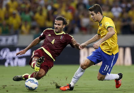 Oscar (R) of Brazil challenges Oswaldo Vizcarrondo of Venezuela during their 2018 World Cup qualifying soccer match in Fortaleza, Brazil, October 13, 2015. REUTERS/Paulo Whitaker