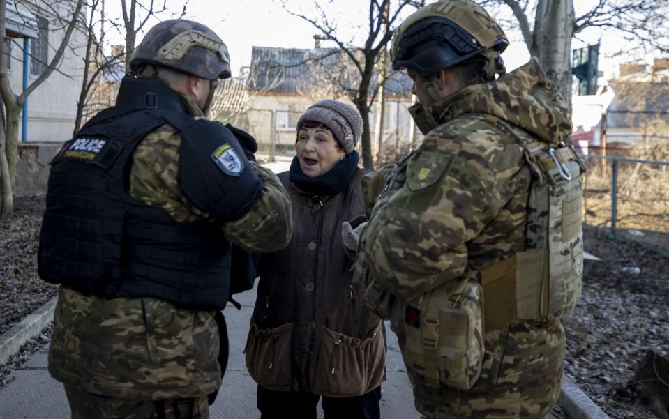 Ukrainian security forces talk to an elder woman while the first anniversary of Russia-Ukraine war approaches in Bakhmut - Anadolu Agency/Anadolu