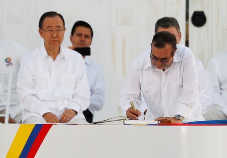 Marxist rebel leader Rodrigo Londono (R), better known by the nom de guerre Timochenko, signs an accord ending a half-century war that killed a quarter of a million people next to United Nations Secretary-General Ban Ki-moon (L), Mexican President Enrique Pena Nieto (2nd L) and Colombian President Juan Manuel Santos (partially obscured) in Cartagena, Colombia September 26, 2016. REUTERS/John Vizcaino/File Photo