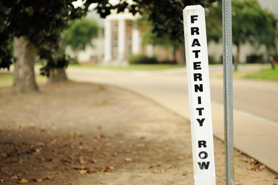 a sign in the ground that reads "fraternity row"