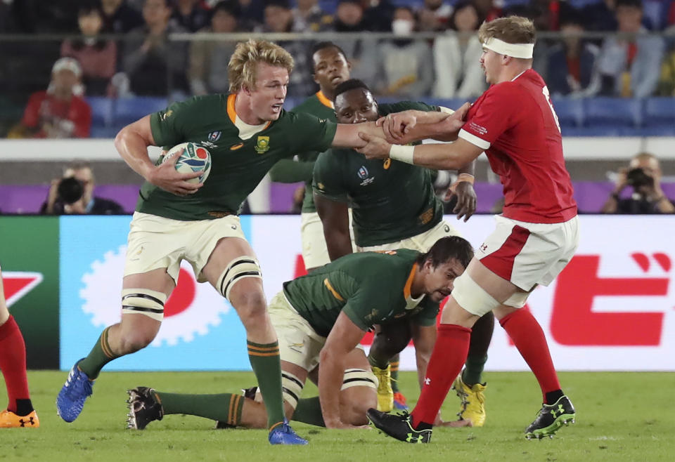 South Africa's Pieter-Steph du Toit, center, fends off Wales' Aaron Wainwright during the Rugby World Cup semifinal at International Yokohama Stadium in Yokohama, Japan, Sunday, Oct. 27, 2019. (AP Photo/Eugene Hoshiko)