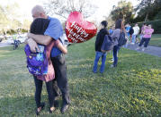 <p>Family member embrace following a shooting at Marjory Stoneman Douglas High School, Feb. 14, 2018, in Parkland, Fla. (Photo: Wilfredo Lee/AP) </p>