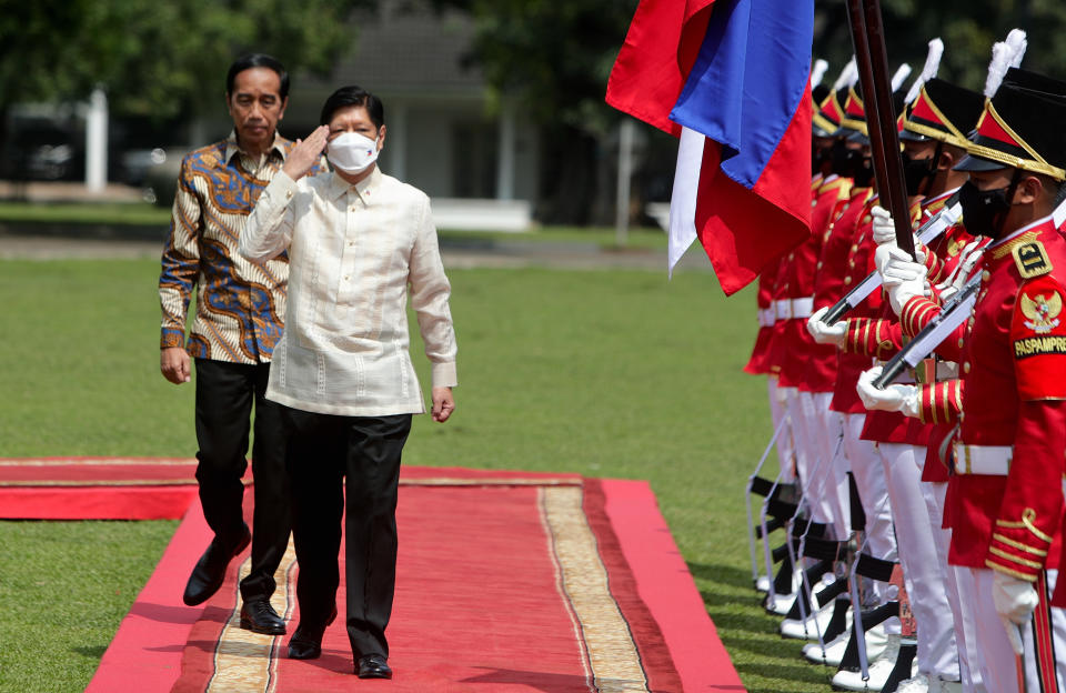 Philippine President Ferdinand Marcos Jr., right, escorted by Indonesian President Joko Widodo, left, inspects an honor guard upon his arrival at the Presidential Palace in Bogor, West Java, Indonesia, Monday, Sept, 5, 2022. (Adi Weda/ Pool Photo via AP)