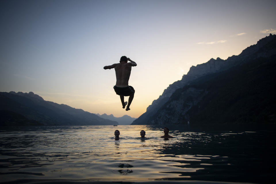 Young people enjoy the evening on lake Walensee, on Tuesday, June 25, 2019, in Walenstadt, Switzerland. The country was hit by a heatwave with temperatures up to 39 degrees celsius. (Gian Ehrenzeller/Keystone via AP)