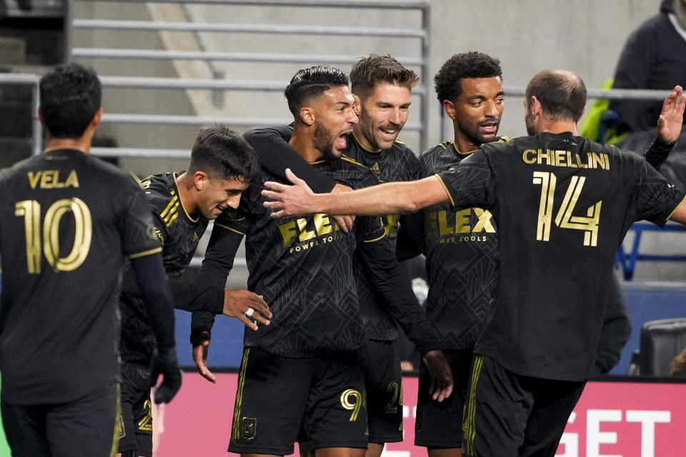 Los Angeles FC forward Denis Bouanga (99) celebrates with teammates, including forward Carlos Vela (10), midfielder Ryan Hollingshead (24), midfielder Timothy Tillman, second from right, and defender Giorgio Chiellini (14) after his goal during the first half of an MLS conference semifinal playoff soccer match against the Seattle Sounders, Sunday, Nov. 26, 2023, in Seattle. (AP Photo/Lindsey Wasson)