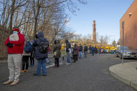 People wait in line to receive the Moderna COVID-19 vaccine at a public high school in Paterson, N.J., Wednesday, Jan. 20, 2021. Paterson's mayor called on the federal government to provide New Jersey with more coronavirus vaccines as the city's walk-in site again drew several hundred people, some of whom had lined up at 4:30 a.m. (AP Photo/Ted Shaffrey)