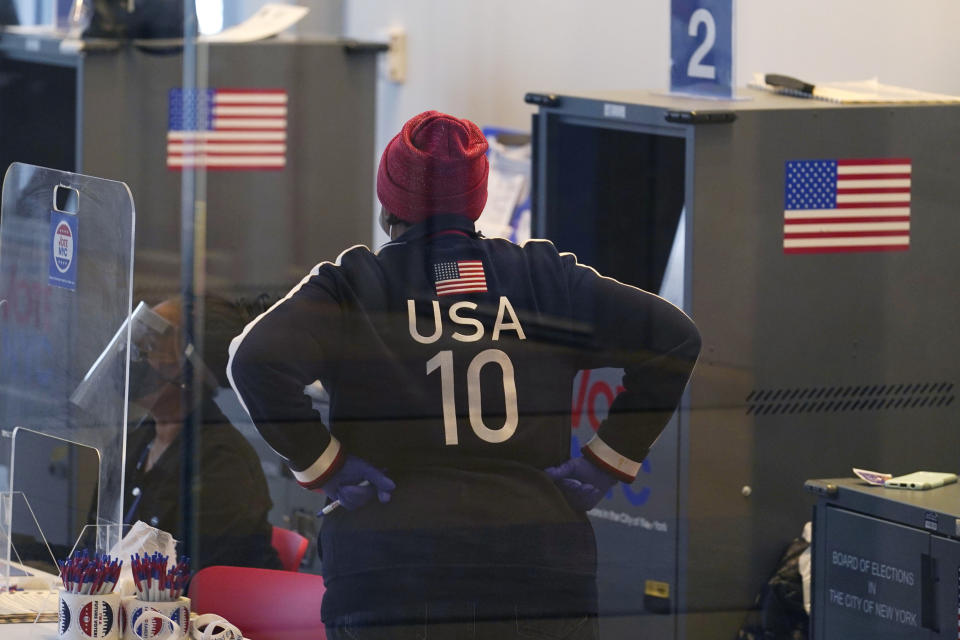 A poll worker wearing patriotic clothing pauses between supervising other workers on the last day of early voting, Sunday, Nov. 1, 2020, at Columbia University's Forum in the West Harlem neighborhood of New York. (AP Photo/Kathy Willens)