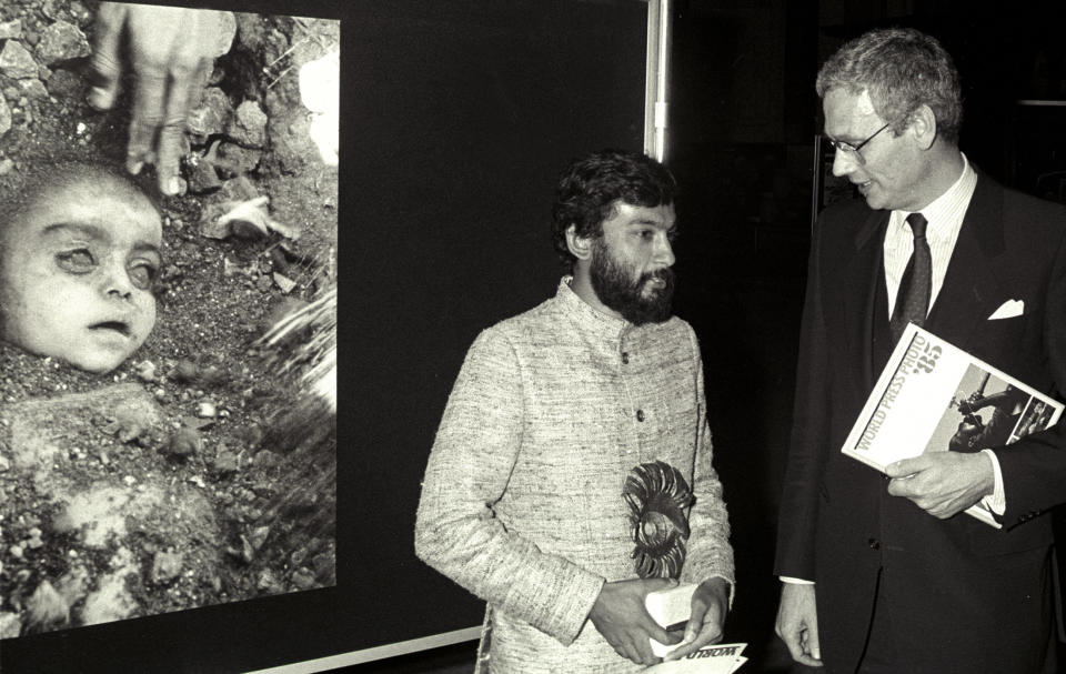 Indian photographer Pablo Bartholomew (L) poses with Dutch Foreign Minister Hans Van Den Broek in Amsterdam, April 14, 1985, after receiving an award for Best World Press Photo of 1984. Behind them is the winning entry, which shows a child victim in his native India of the Bhopal disaster, caused by a gas leak from the Union Carbide pesticide plant. Photo: Scanned from negative Reuters/E. Werner CMC