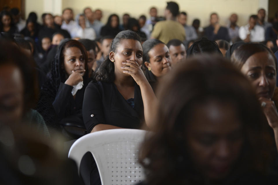 Mourners attend a memorial service held by an association of Ethiopian airline pilots, at which framed photographs of seven crew members were on display, in Addis Ababa, Ethiopia Monday, March 11, 2019. Authorities in Ethiopia, China and Indonesia grounded all Boeing 737 Max 8 aircraft Monday following the crash of an Ethiopian Airlines jetliner that killed 157 people, and investigators found the flight recorders from the field where the plane went down. (AP Photo/Samuel Habtab)