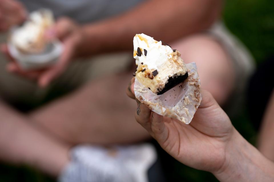 People eat Cheesecake from The Cheesecakery at Taste of Cincinnati 2023. The Cheesecakery's Oreo Cheesecake Cupcake won gold for Best of Taste desserts among restaurants for 2024.