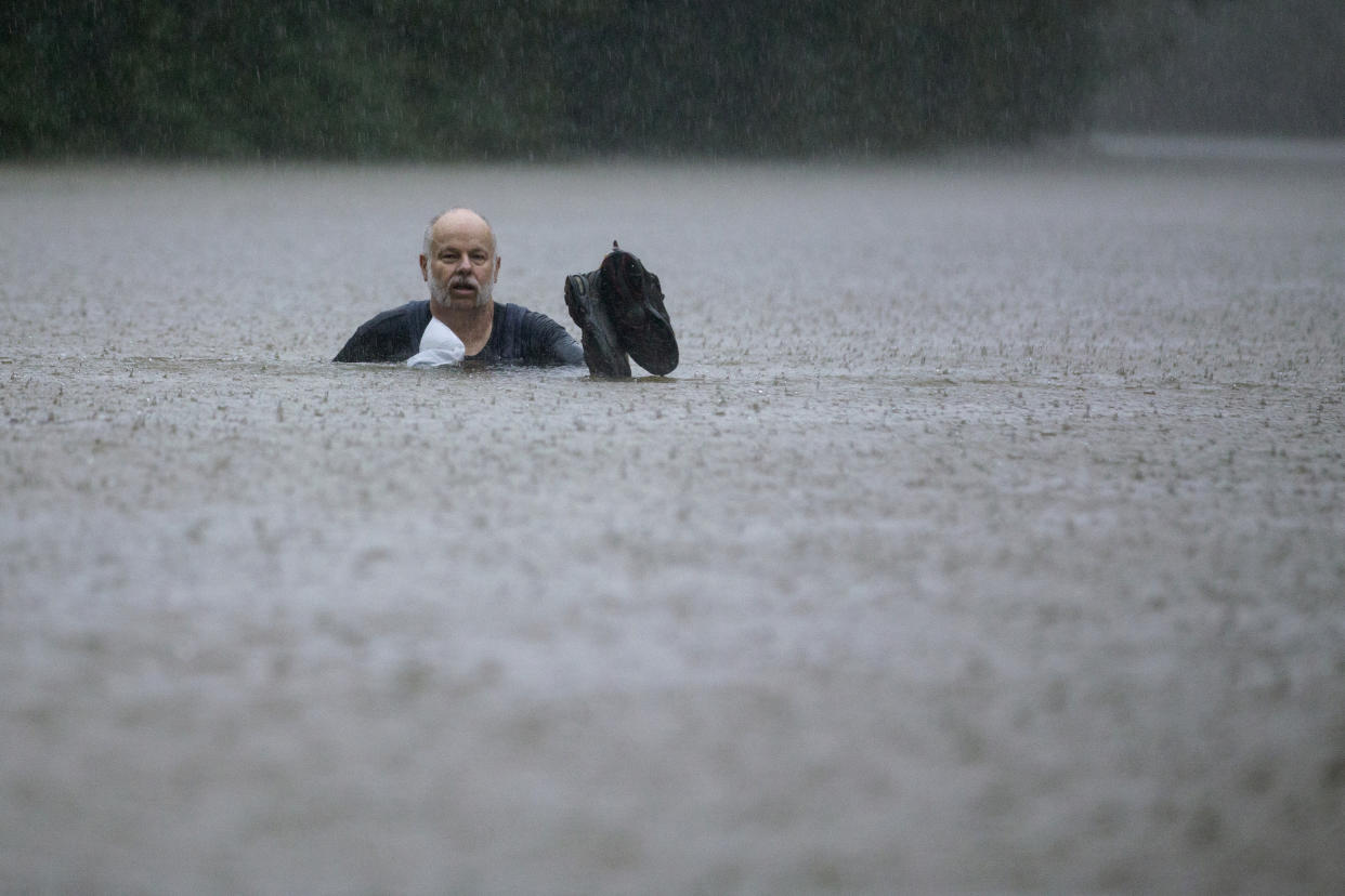 A man wades out through floodwaters caused by heavy rain spawned by Tropical Depression Imelda inundated the area on Sept. 19, 2019, in Patton Village, Texas. (Photo: Brett Coomer/Houston Chronicle via AP)