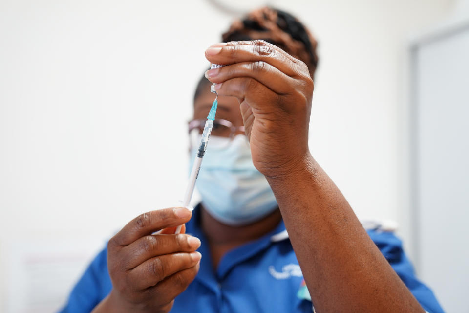 COVENTRY, ENGLAND - APRIL 22: A nurse prepares a dose of a Covid-19 vaccine for Margaret Keenan, 91, prior to her receiving a spring Covid-19 booster shot at University Hospital Coventry on April 22, 2022 in Coventry, England. Mrs Keenan, known as Maggie, was the first patient in the United Kingdom to receive the Pfizer/BioNtech Covid-19 vaccine. (Photo by  Jacob King - WPA Pool / Getty Images)