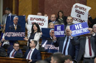 Lawmakers hold pictures of assassinated Kosovo Serb politician Oliver Ivanovic and banners that read: "Not to the ultimatum!" and "Vucic, betrayed Kosovo", during a special session of Serbia's parliament about the negotiating process with Kosovo in Belgrade, Serbia, Thursday, Feb. 2, 2023. Serbia fought a 1998-99 war with ethnic Albanian separatists in Kosovo, which at the time was a Serbian province. A NATO intervention that forced Serbia to pull out of the territory ended the war, but tensions over Kosovo's status remains a source of instability in the Balkans. (AP Photo/Darko Vojinovic)