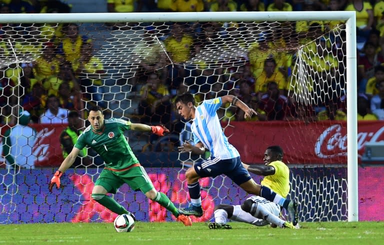 Argentina's Paulo Dybala (C) drives the ball past Colombia's Cristian Zapata (R) as Colombia's David Ospina looks on during their Russia 2018 FIFA World Cup South American Qualifiers football match, in Barranquilla, Colombia, on November 17, 2015