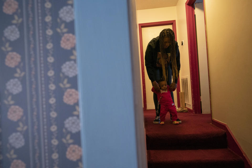 Ansonia Lyons walks down the corridor of her parents' home with her son, Adrien Lyons, in Birmingham, Ala., on Saturday, Feb. 5, 2022. Black Americans’ health issues have long been ascribed to genetics or behavior, when in actuality, an array of circumstances linked to racism - among them, restrictions on where people could live and historical lack of access to care - played major roles. (AP Photo/Wong Maye-E)