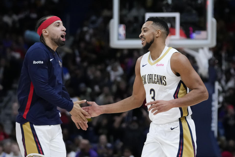 New Orleans Pelicans guard CJ McCollum (3) is greeted by guard Jose Alvarado after a scoring run in the first half of an NBA basketball game against the Los Angeles Lakers in New Orleans, Sunday, Dec. 31, 2023. (AP Photo/Gerald Herbert)