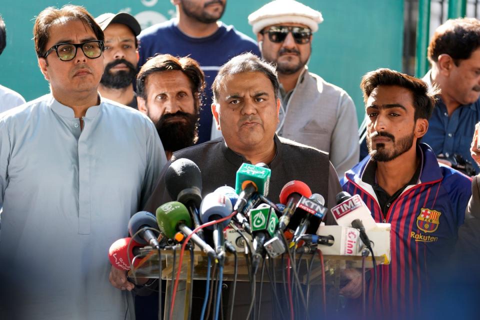 Fawad Chaudhry (centre), a senior member of former prime minister Imran Khan’s party, addresses the media outside the Election Commission (AP)