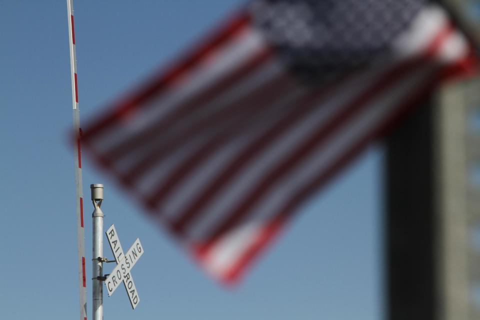 A flag flies at the scene of an accident where four veterans were killed and 16 other people were injured when a train slammed into a parade float carrying the returning heroes to a banquet last Thursday in Midland, Texas on Saturday, Nov. 17, 2012. Federal investigators were trying to determine whether the two-float parade had been given enough warning to clear the tracks. (AP Photo/Juan Carlos Llorca)