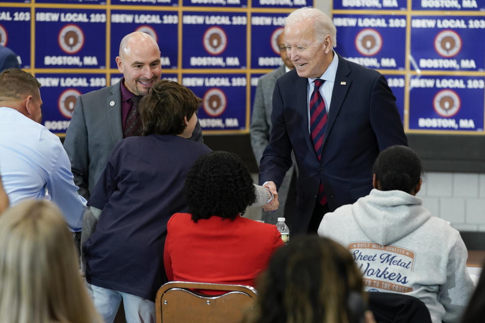 President Joe Biden greets people as he visits a phone bank at International Brotherhood of Electrical Workers Local 103, Friday, Dec. 2, 2022, in Boston. (AP Photo/Patrick Semansky)