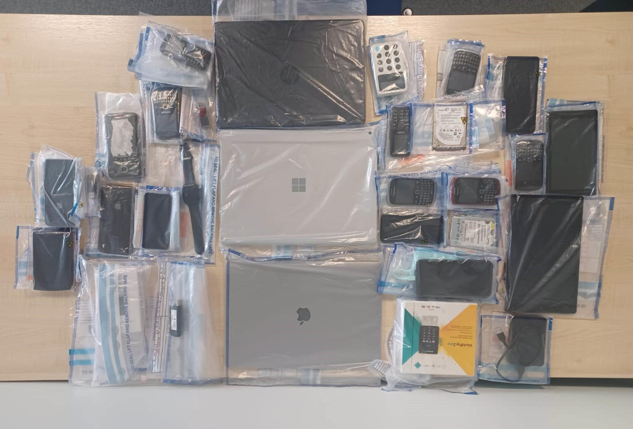 Phones, laptops and tablets seized by the police as part of the investigation. (Metropolitan Police/PA)
