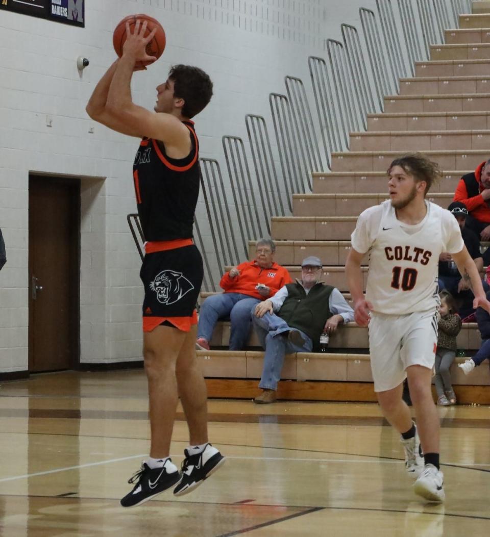 New Lexington senior Lukas Ratliff (11) gets off a jump shot as Meadowbrook's Justice Huey arrives too late during Friday's MVL game in Byesville.