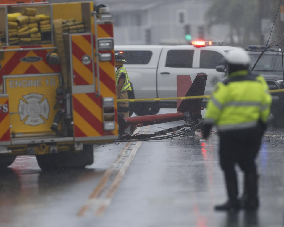 The tail of a crashed helicopter is seen in the middle of the street. Source: AP