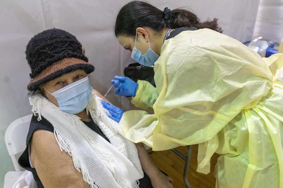 Registered Nurse Rita Alba gives a patient the first dose of the coronavirus vaccine at a pop-up COVID-19 vaccination site at the Bronx River Community Center, Sunday, Jan. 31, 2021, in the Bronx borough of New York. (AP Photo/Mary Altaffer)