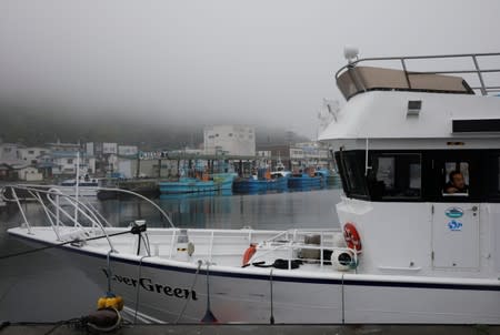 Whale-watching boat captain Masato Hasegawa speaks with other boats in order to look for whales in the sea near Rausu